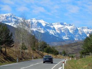 Pyrenäen - Landstraße : Landstraße vor schneebedeckten Berggipfeln. Aufgenommen in den spanischen Pyrenäen bei Berga am 17. April 2012