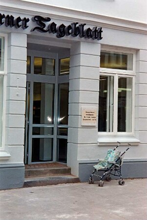 Mühlenstraße 21: giebelständiges Wohn- und Geschäftshaus: nach Sanierung: Straßenfront: Erdgeschoss, Teilansicht: zurückgesetzte Eingangstür, Firmenschild Stormarner Tageblatt