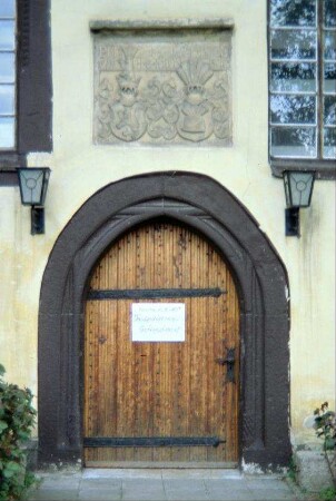 Kirchenportal mit Wappenstein darüber