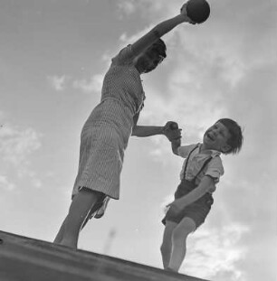 Elisabeth Gremmler und ihr Kind spielen Ball auf einer Treppe