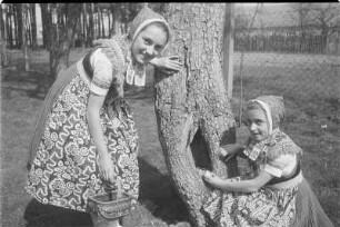 Schleifer Mädchen beim Ostereiersuchen in Rohne. : Holcy w Slepjanskej drasće při pytanju jutrownych jejkow pola Wěrikec w Rownom.