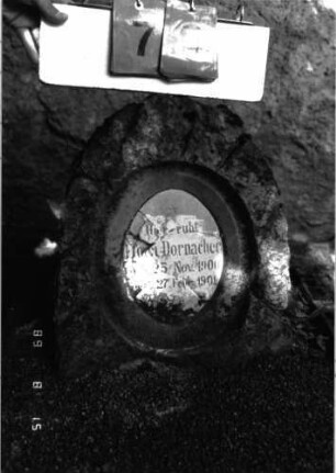 Grabstein 79 (Index: 100105571) Material: Granit, weiße Marmorplatte Zustand: Platte mehrfach gesprungen Maße HxBxT: 51x43x25 cm Beschreibung: Stele, rustica, ovale Schriftplatte Symbolik: Sternchen auf Schriftplatte Besonderheit: Kindergrab: Grabstein 79