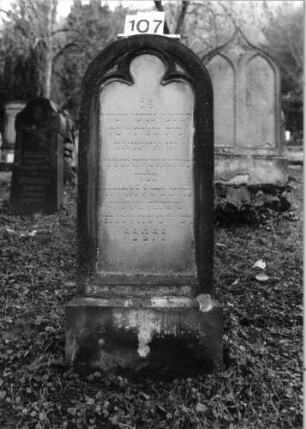 Grabstein 107 (Index: 100092929) Material: Sandstein Zustand: gut Maße HxBxT: 124x54x24 cm Beschreibung: aufgesockelte Stele mit barockisierendem Abschluß, vertieftes Schriftfeld: Grabstein 107