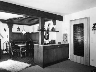 Möbelaufnahmen. Wohnküche. Sitzecke mit Holzdecke und Anrichte. An der Wand eine Gitarre