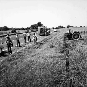 Mord an Brigitte Wetzenstein-Ollenschläger: Bundesautobahn A 1 bei Reinfeld: Leichenfundort im Graben neben Seitenstreifen am 19. August 1972: rechts Trecker nach Mähen eines Teils des Grases und des angrenzenden Getreidefeldes: links Polizisten und Männer am Straßenrand zwischen Pkw und Polizeifahrzeug: hinten Bäume