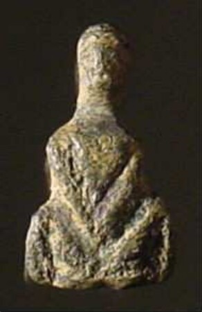 Kleine Statuette einer mit gespreizten Beinen hockenden nackten Frau, im Nacken eine Öse