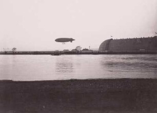 Luftschiff "Parseval" und Luftschiffhalle in Dresden-Kaditz : Dresden-Kaditz, Luftschiffhalle. Halbstarres Luftschiff "Parseval" im Flug neben der Halle (1910 erstmalig in Dresden), 1914.03.22