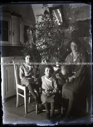 Familie mit drei Kinder am Weihnachtsbaum in der der Küche