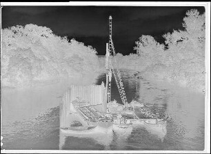 Staustufe Schweinfurt. Straßenbrücke. Rammen der Umspundung für den Pfeiler 4 im Saumain. Blick von der Marienbrücke nach oberstrom. Wasserspiegel im Saumain NN + 205,37 m.