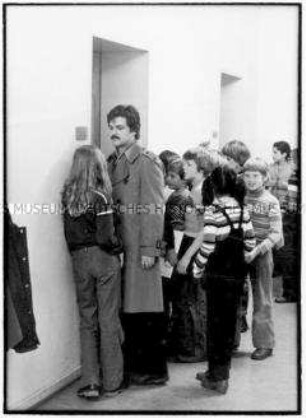 Lehrer mit Schülern vorm Klassenzimmer (Altersgruppe 14-17)