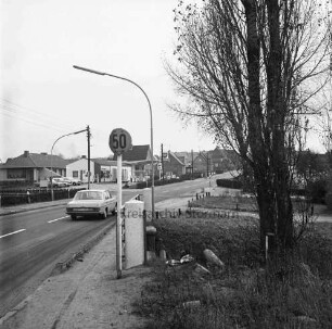 Möllner Landstraße: rechts Forellenbach mit Bäumen: links Brücke mit Straßenschild: dahinter Pkw: hinten Tankstelle und Wohnhäuser
