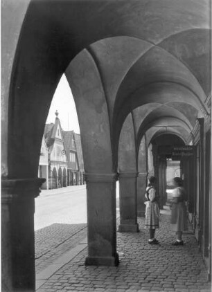 Hohenelbe (Vrchlabí). Arkaden am Modewarengeschäft von Robert Preißler. Ansicht mit zwei jungen Mädchen