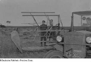 Landwirte beim Mähen von Getreide mit Hilfe eines Traktors und einer Mähmaschine
