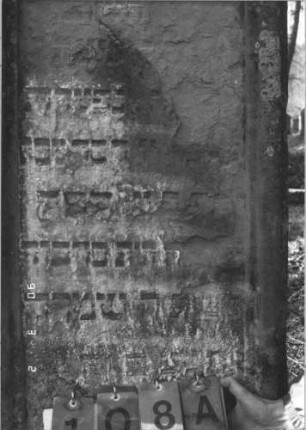 Grabstein 108 (Index: 99608792) Material: Sandstein Zustand: stark verwittert mit Textverlust Maße HxBxT: 141x62x13 cm Beschreibung: Stele mit geschwungenem, gespaltenem Bogen, vertiefter Textteil: Grabstein 108A