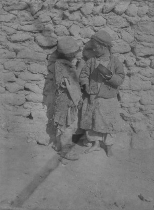 Kinder aus Zentralasien : Zwei zentralasiatische Kinder vor einer Mauer im Tian Shan Hochgebirge