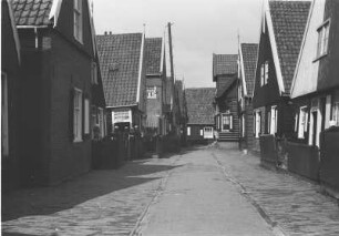Dorfstraße : Straßenflucht mit Holzhäusern