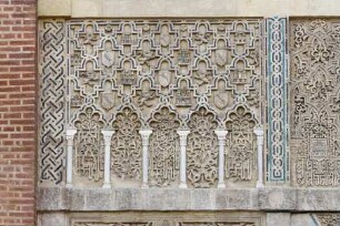 Reliefierte Fassadenzone — Linkes Relieffeld mit Sebkaornament, fächerbogigen Blendarkaden und Wappensymbolik