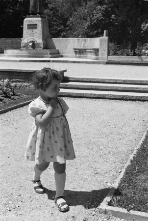 Privataufnahmen. Bad Wörishofen, Denkmalplatz. Kleines Mädchen beim Spaziergang an der Denkmalsanlage für Sebastian Kneipp