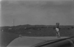 Frau mit Korb : Frau mit Korb auf dem Kopf vermutlich aus einem fahrenden Fahrzeug fotografiert.