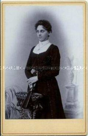 Junge Frau im dunklen Kleid mit Fächer