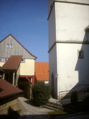 Kirchhof im Norden nach Osten mit Kirchturm (im Kern gotisch) von Westen sowie Torhaus im Nordosten