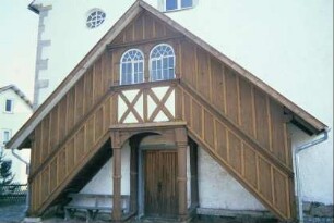 Eingangsbereich der Kirche mit überdachtem Treppenaufgang zur Empore