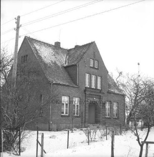 Volksschule: davor Zaun: rechts und links Bäume: hinten links Strommast: Winter