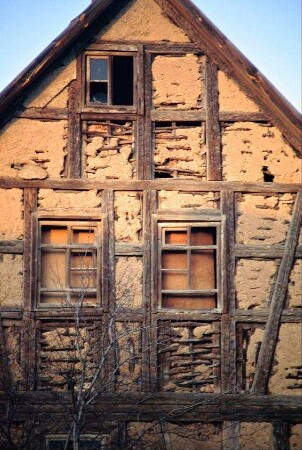 verlassenes Haus, Fenster ohne Glas, Fachwerk mit Staken und Lehmausschlag