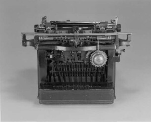 Typenhebelschreibmaschine "Remington" (Modell 7). Unteranschlag (nicht sofort sichtbare Schrift), Universaltastatur mit 42 Tasten, 23-mm-Farbband. Rückansicht