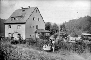 Wohnhaus und Frauen mit Kinderwagen