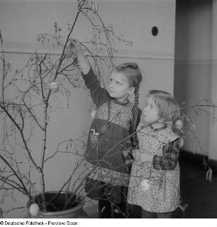 Kinder beim Schmücken eines Baums im Kindergarten