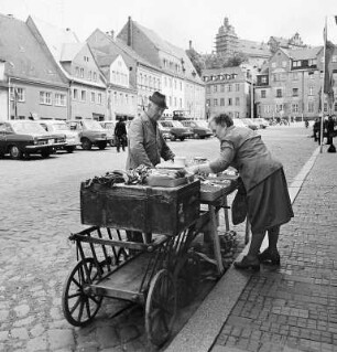 Kurzwarenhändler mit Handwagen auf dem Markt