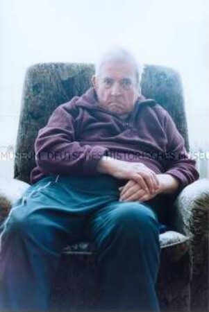 Älterer, männlicher Heimbewohner in einem Sessel sitzend (Prämiertes Foto)