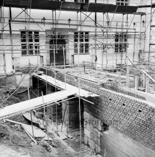 Restaurierung: Brücke vor Eingangsportal: bei Wiederherstellung, mit Gerüst: Aufmauern der Gewölbe mit Klinker, Überweg mit Verschalung, Baustahl-Armierung: vorne links und hinten rechts zugeschütteter innerer Graben vor Aushebung: Schlossfassade mit Gerüst