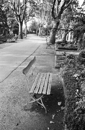 Gartenbänke und Gartenstühle vor Gräbern auf dem Karlsruher Hauptfriedhof
