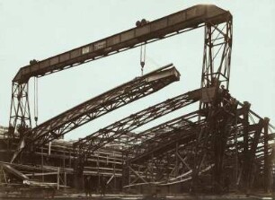 Baustelle Bahnhof Dresden-Neustadt. Stahlhochbauarbeiten durch die Maschinenfabrik Augsburg-Nürnberg - Brückenbau-Anstalt Gustavsburg. Montage der Dachbinder einer Seitenhalle der Bahnsteighalle mit Portalkran : Dresden-Neustadt, Schlesischer Platz. Baustelle Bahnhof Dresden-Neustadt. Stahlhochbauarbeiten durch die Maschinenfabrik Augsburg-Nürnberg - Brückenbau-Anstalt Gustavsburg. Montage der Dachbinder einer Seitenhalle der Bahnsteighalle mit Portalkran