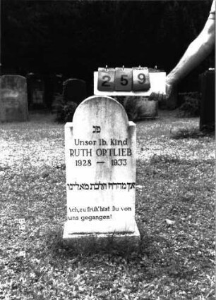 Grabstein 259 (Index: 100101370) Material: weißer Marmor, Sockel Kalkstein Zustand: gut Maße HxBxT: 86x34x15 cm Beschreibung: Stele, Sockel, eingezogener Rundbogenabschluß Besonderheit: Kindergrab: Grabstein 259