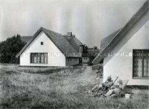 Urlauber vor reetgedecktem Fischerhaus auf der Ostseeinsel Hiddensee