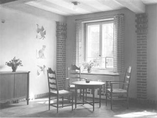 Interieur mit Anrichte, Tisch und drei Stühlen. Ansicht an die Wand gemalten Tieren