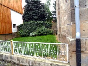 Haddamar-Evangelische Kirche - Kirchhof im Osten mit Kirchhofmauerrest (Werksteine im Mauersteinverband - beachte Werkstein mit Zangenloch (15 Jhd) im Süden)