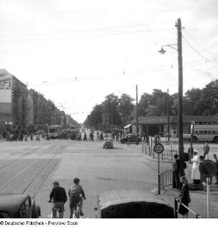 Berlin. Blick über eine Straßenkreuzung, links Wohn-und Geschäftshäuser