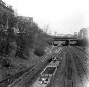 Deutschland. Güterzug mit Jugendlichen auf einem Wagon beim Durchfahren einer Brücke