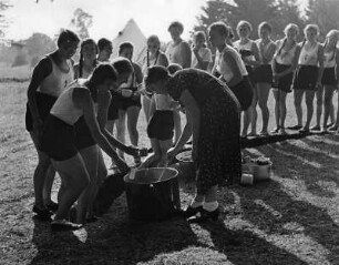 Reinwarzhofen. Zeltlager des Bundes Deutscher Mädel (BdM) auf dem Zeltlagerplatz "Göring-Espan". Mädchengruppe in Sportbekleidung, am Teeausschank im Freien anstehend