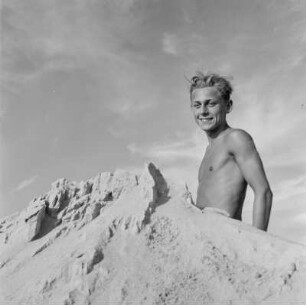 Ein Jugendlicher sitzt am Strand