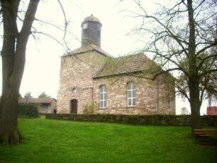 Hermannrode-(Evangelische Kirche) - Ansicht von Süden mit Kirchturm (beachte Geschoßrücksprung) und Langhaus über Kirchhofmauer
