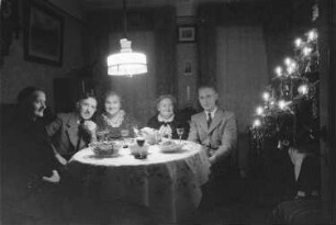 Private Aufnahmen. Franz Grasser mit einer Familie neben dem Weihnachtsbaum