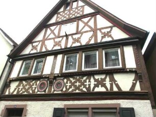 Stadtbild-St Lioba Straße - Haus Nr 24-Giebelständiges Haus mit Obergeschossen in Fachwerk-Ornamentierung (Holzschnitzerei) mit Farbigkeit