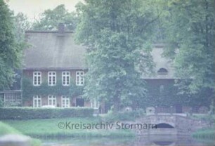 Mühlenredder 1: Schlossmühle mit Reetdach: mit Durchlass für Mühenwehr: vorne äußerer Schlossgraben