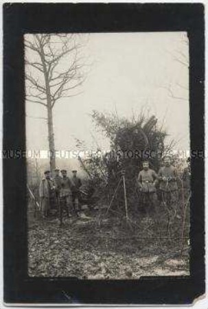 Soldaten vor getarnter Kanone