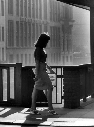 Hamburg-Altstadt. Eine junge Frau überquert dei Schleusenbrücke, die denRathausmarkt und die Poststraße verbindet. Unter der Brücke befindet sich die Rathausschleuse